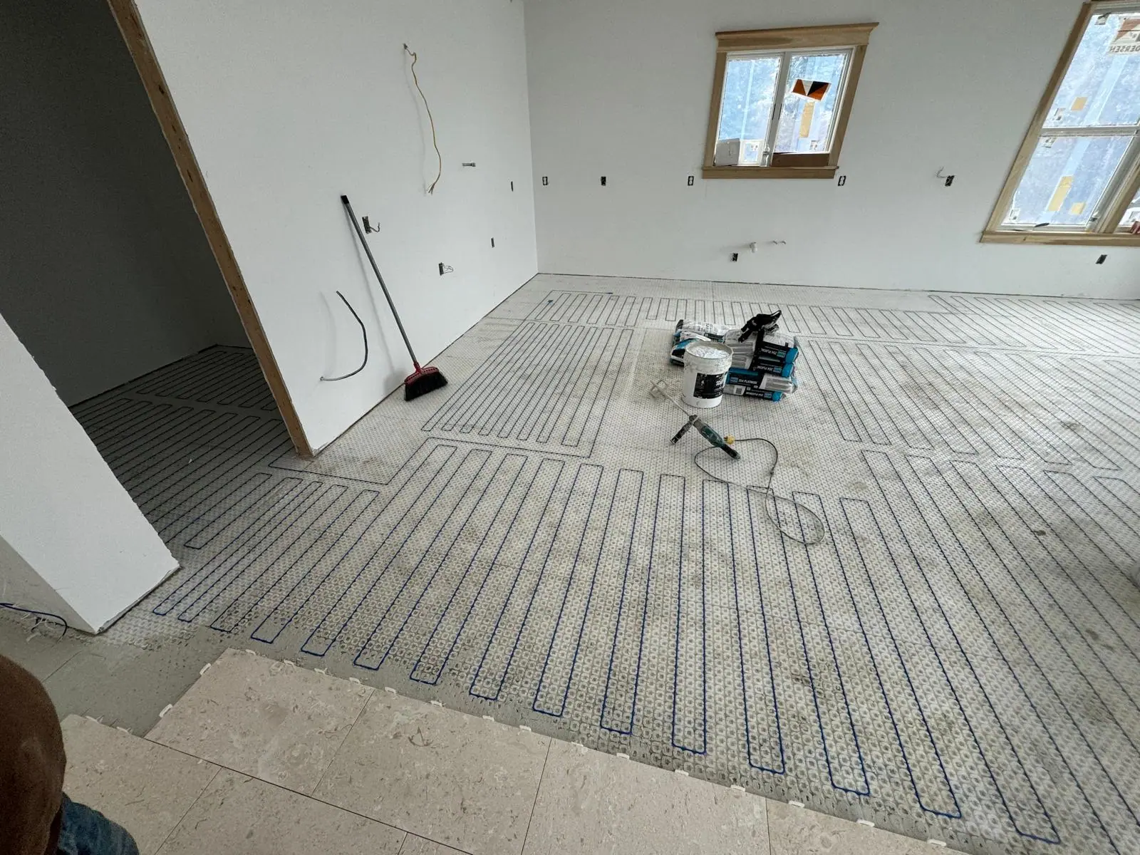 Heating cable membrane being covered with tile in a room under construction